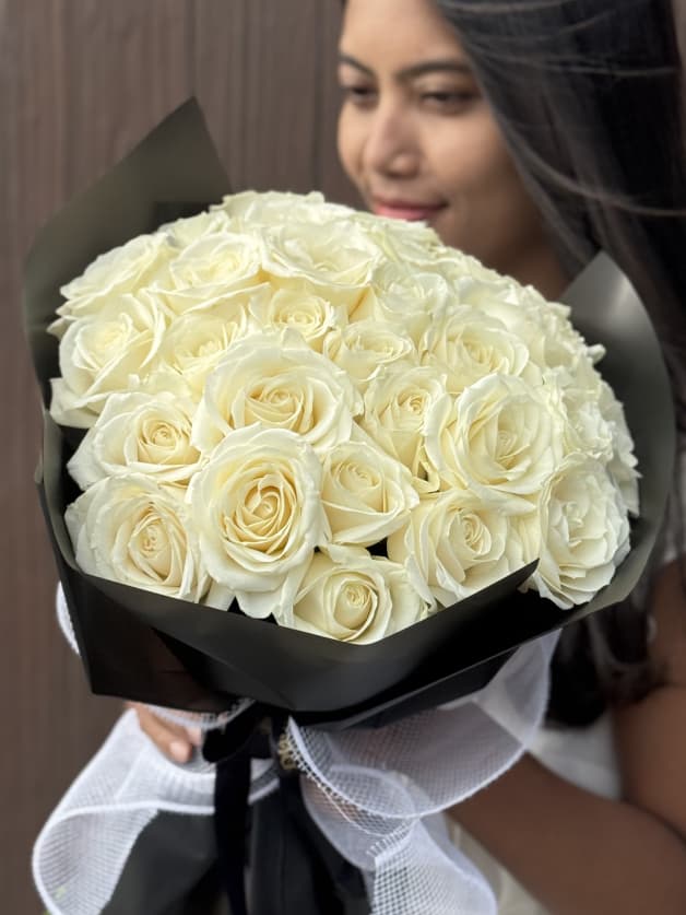 A pristine bouquet of 31 white Holland roses